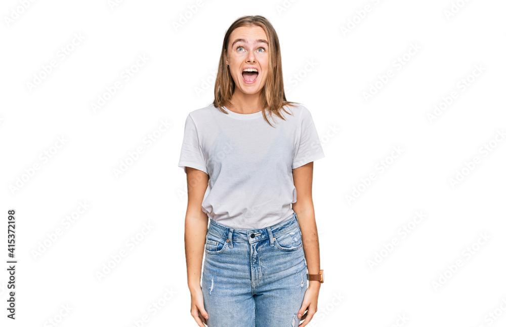 Beautiful young blonde woman wearing casual white t shirt angry and mad screaming frustrated and furious, shouting with anger. rage and aggressive concept. Beautiful young blonde woman wearing casual white t shirt angry and mad screaming frustrated and furious, shouting with anger. rage and aggressive concept.