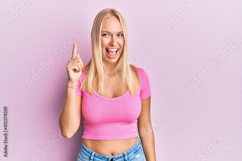 Young blonde girl wearing casual clothes pointing finger up with successful idea. exited and happy. number one. © Krakenimages.com