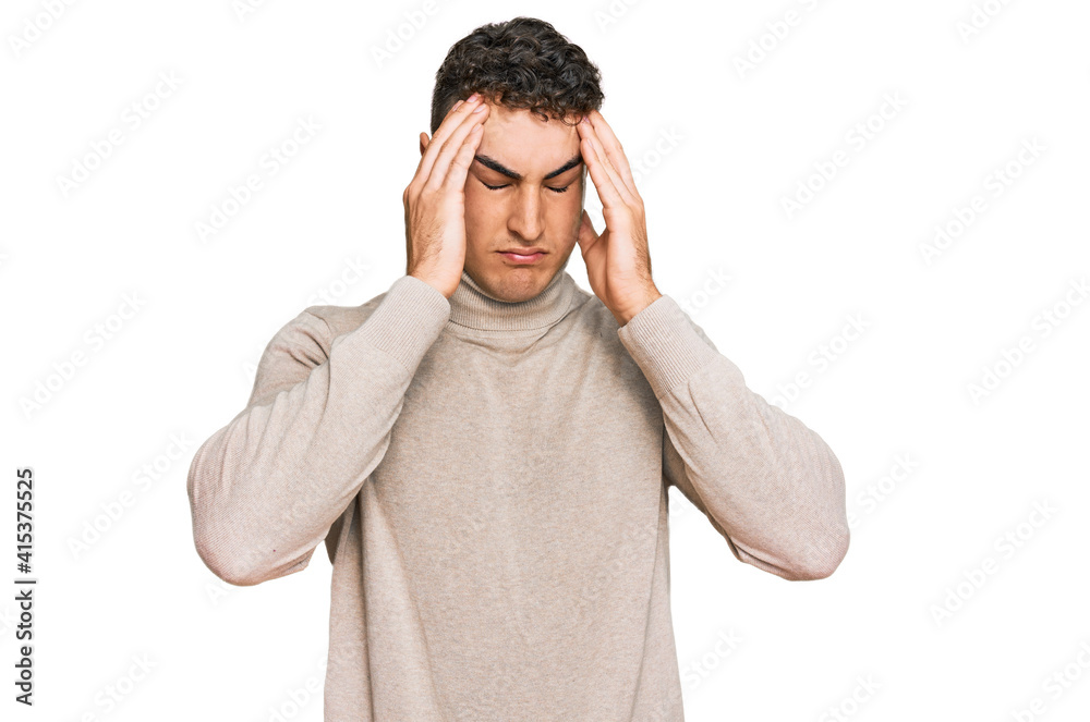 Naklejka premium Hispanic young man wearing casual turtleneck sweater suffering from headache desperate and stressed because pain and migraine. hands on head.