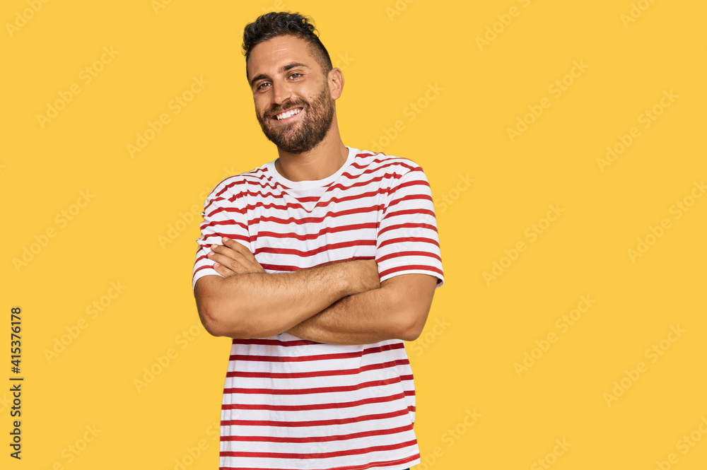 Handsome man with beard wearing striped tshirt happy face smiling with crossed arms looking at the camera. positive person. Handsome man with beard wearing striped tshirt happy face smiling with crossed arms looking at the camera. positive person.