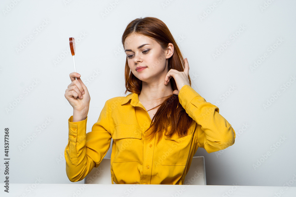 cheerful woman with heart shaped lollipop sitting at the table lifestyle cheerful woman with heart shaped lollipop sitting at the table lifestyle