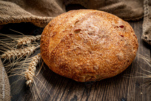 Freshly baked traditional bread on wooden table.