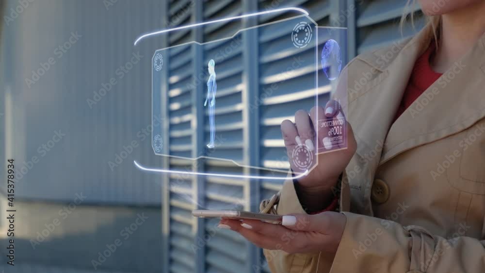 Unrecognizable businesswoman interacts HUD hologram with young female body of particles. Woman in the coat uses technology of the future mobile screen on background of the city