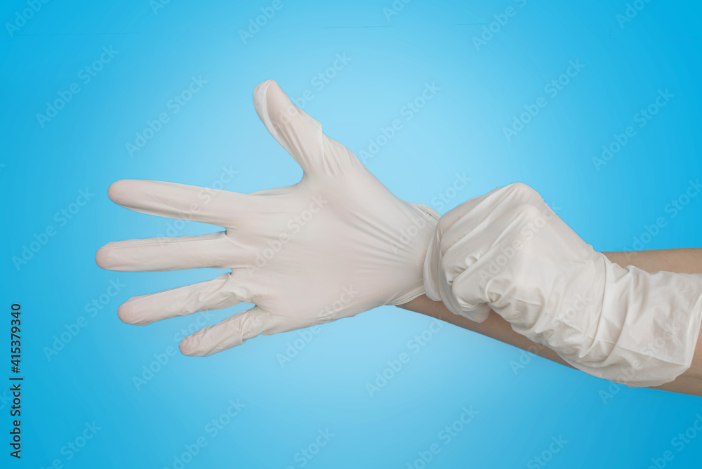 white medical rubber gloves on the hands on a blue background. the concept of protecting your hands from viruses and germs