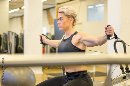 Sporty middle-aged woman working out in a gym