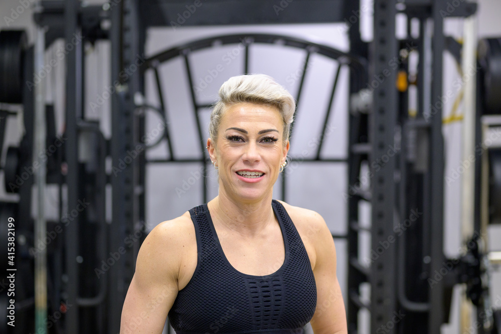 Obraz premium Attractive fit sporty blond woman posing in a gym