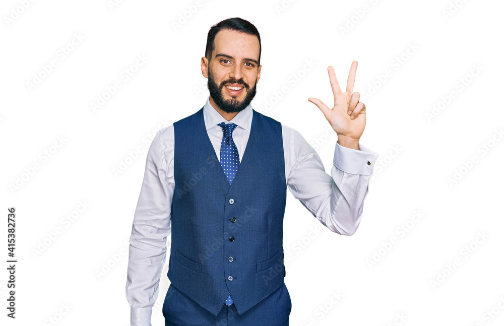 Young man with beard wearing business vest showing and pointing up with fingers number three while smiling confident and happy. Young man with beard wearing business vest showing and pointing up with fingers number three while smiling confident and happy.