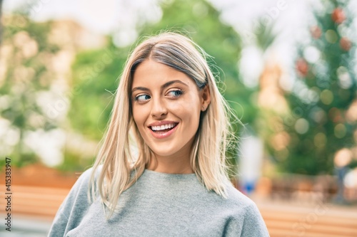 Young blonde girl smiling happy standing at the park.
