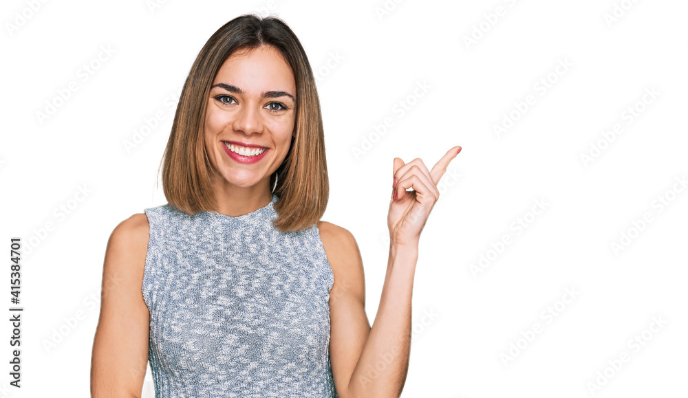 Young blonde girl wearing casual style with sleeveless shirt smiling happy pointing with hand and finger to the side Young blonde girl wearing casual style with sleeveless shirt smiling happy pointing with hand and finger to the side