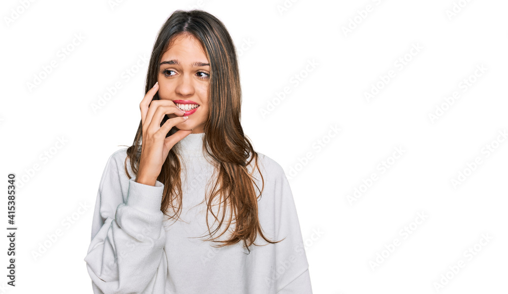 Young brunette woman wearing casual turtleneck sweater looking stressed and nervous with hands on mouth biting nails. anxiety problem. Young brunette woman wearing casual turtleneck sweater looking stressed and nervous with hands on mouth biting nails. anxiety problem.