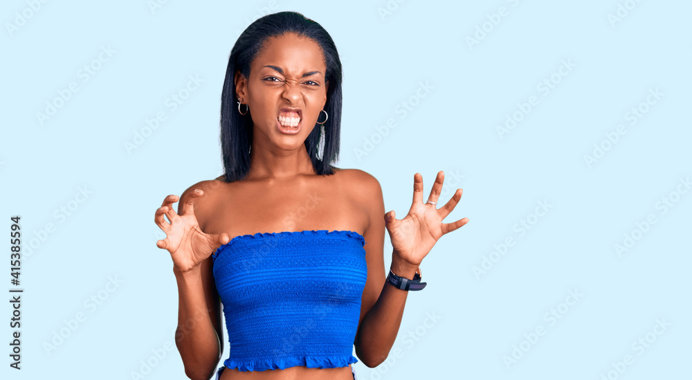 Young african american woman wearing casual summer clothes smiling funny doing claw gesture as cat, aggressive and sexy expression Young african american woman wearing casual summer clothes smiling funny doing claw gesture as cat, aggressive and sexy expression