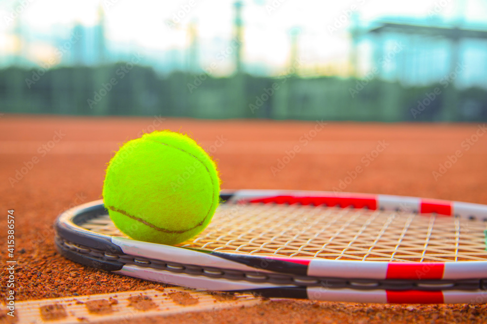 Tennis racket and tennis ball on clay court