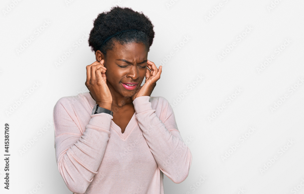 Young african american girl wearing casual clothes covering ears with fingers with annoyed expression for the noise of loud music. deaf concept. Young african american girl wearing casual clothes covering ears with fingers with annoyed expression for the noise of loud music. deaf concept.