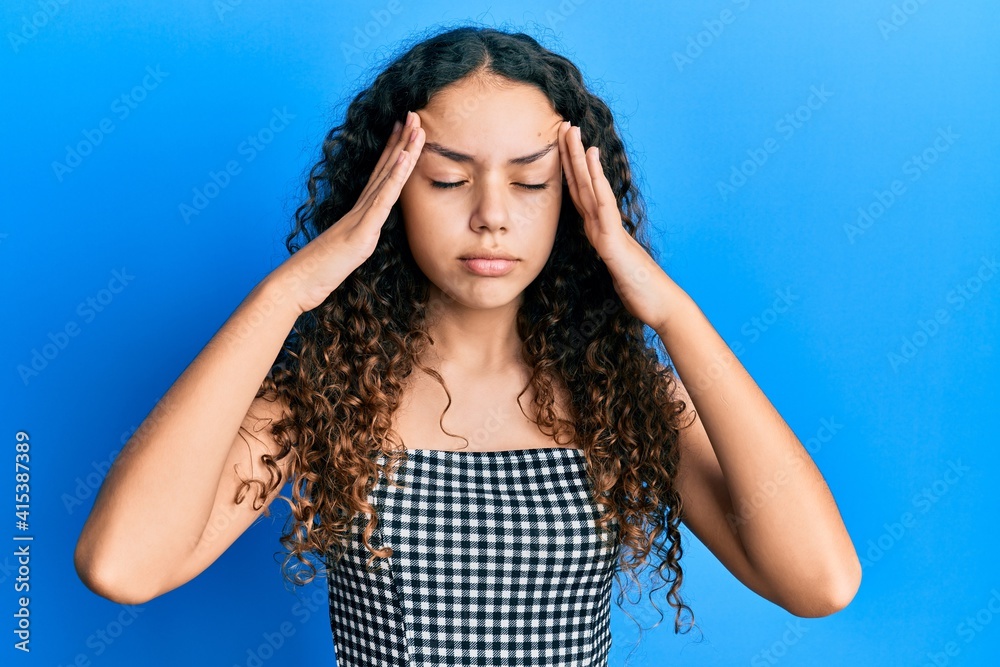Teenager hispanic girl wearing casual clothes with hand on head, headache because stress. suffering migraine. Teenager hispanic girl wearing casual clothes with hand on head, headache because stress. suffering migraine.