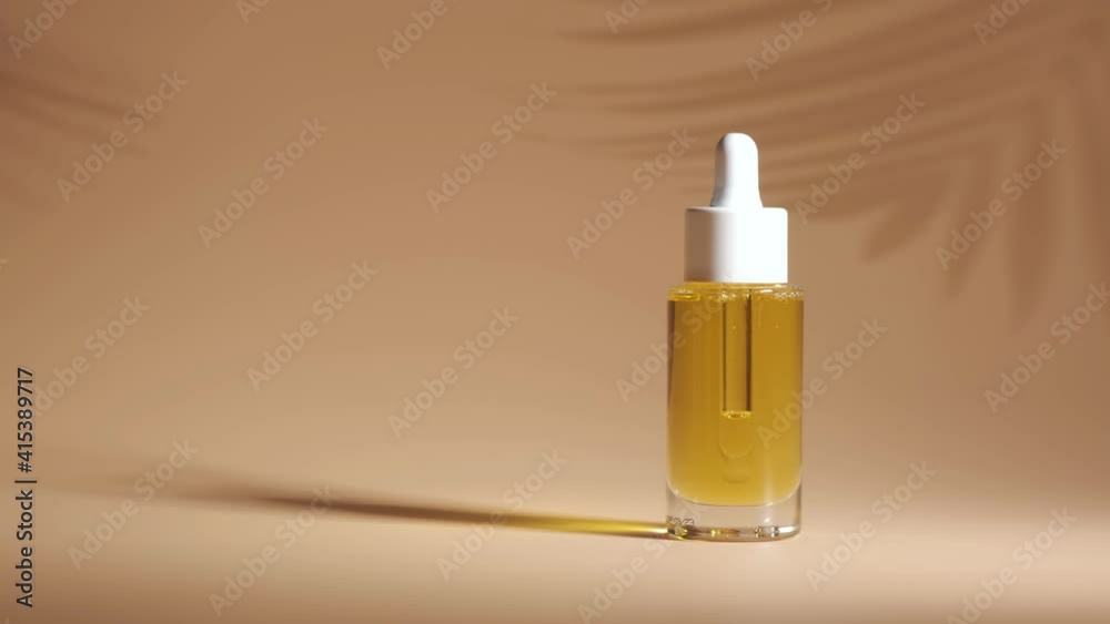 Serum in glass bottle on beige background. Aromatherapy oil. Natural cosmetic.