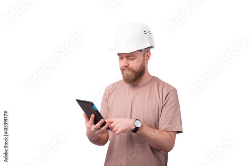 Young engineer man using tablet and wearing hardhat over white background