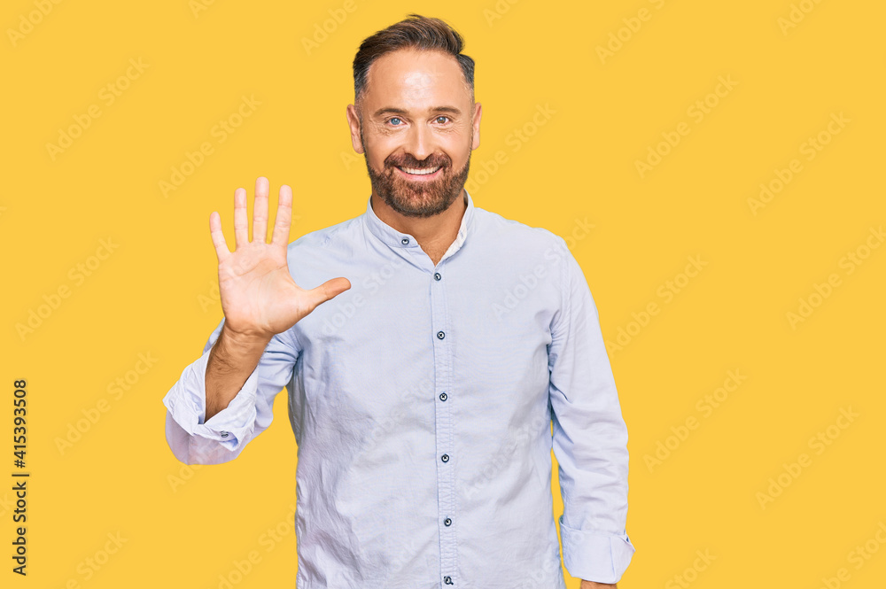 Handsome middle age man wearing business shirt showing and pointing up with fingers number five while smiling confident and happy. Handsome middle age man wearing business shirt showing and pointing up with fingers number five while smiling confident and happy.