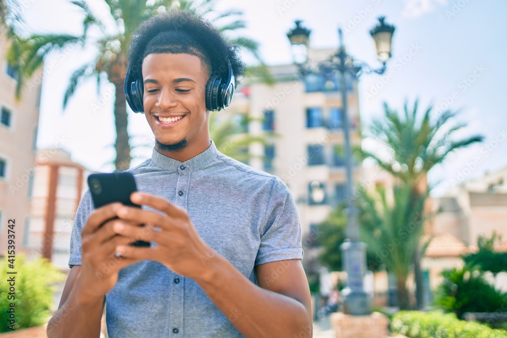 custom made wallpaper toronto digitalYoung african american man smiling happy using smartphone and headphones at the city.