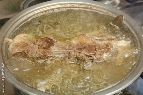 Pork meat is cooked in fat broth. Casserole with soup close-up, selective focus