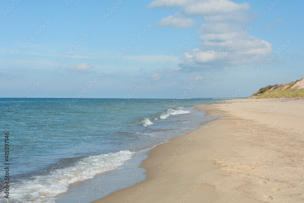 Obraz premium Soft waves with white foam on shore of sand. Vacation and travel concept