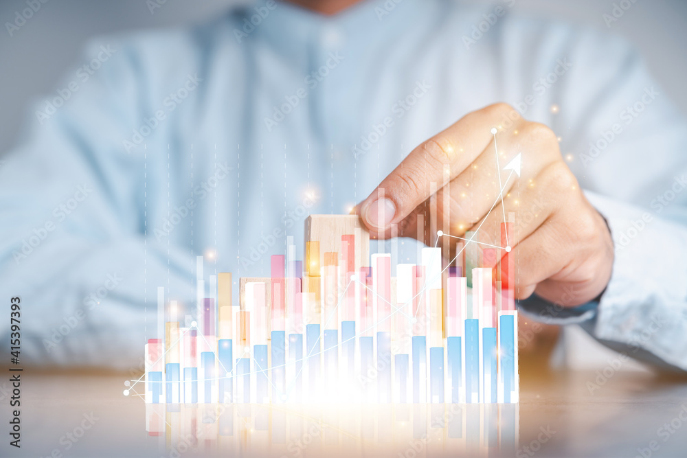 Businessmen use a handle on the wooden block to show stock graphs and rising stock signals with chart indicators. Concepts of financial interest rates and mortgage rates. Businessmen use a handle on the wooden block to show stock graphs and rising stock signals with chart indicators. Concepts of financial interest rates and mortgage rates.