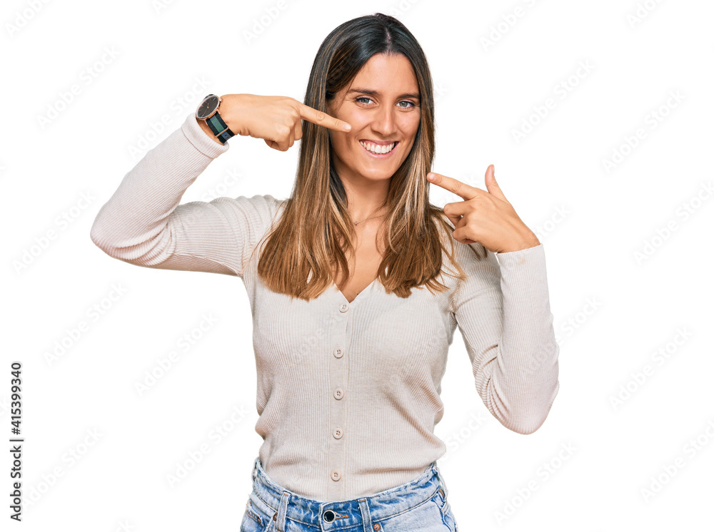Young woman wearing casual clothes smiling cheerful showing and pointing with fingers teeth and mouth. dental health concept. Young woman wearing casual clothes smiling cheerful showing and pointing with fingers teeth and mouth. dental health concept.
