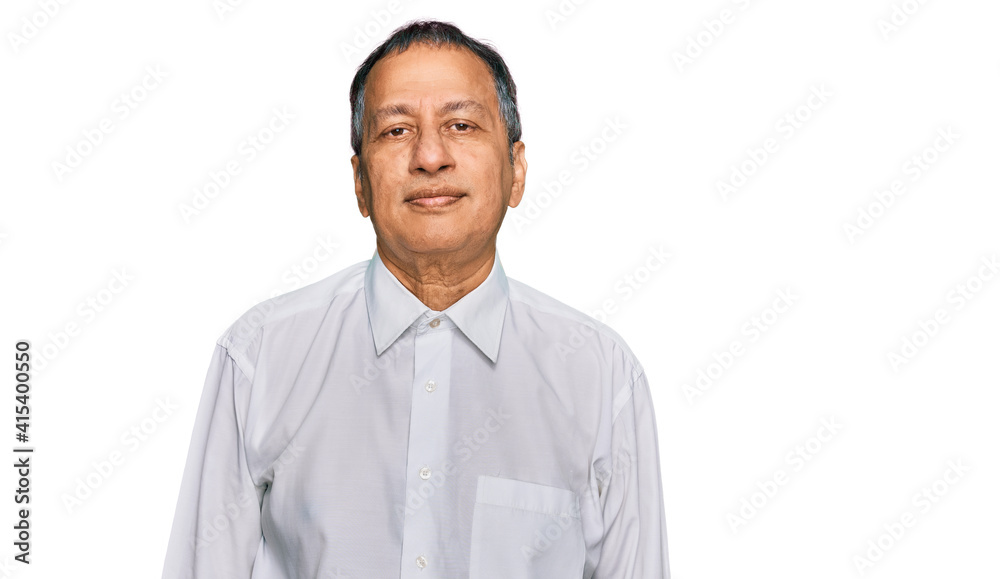 Middle age indian man wearing casual white shirt with serious expression on face. simple and natural looking at the camera. Middle age indian man wearing casual white shirt with serious expression on face. simple and natural looking at the camera.