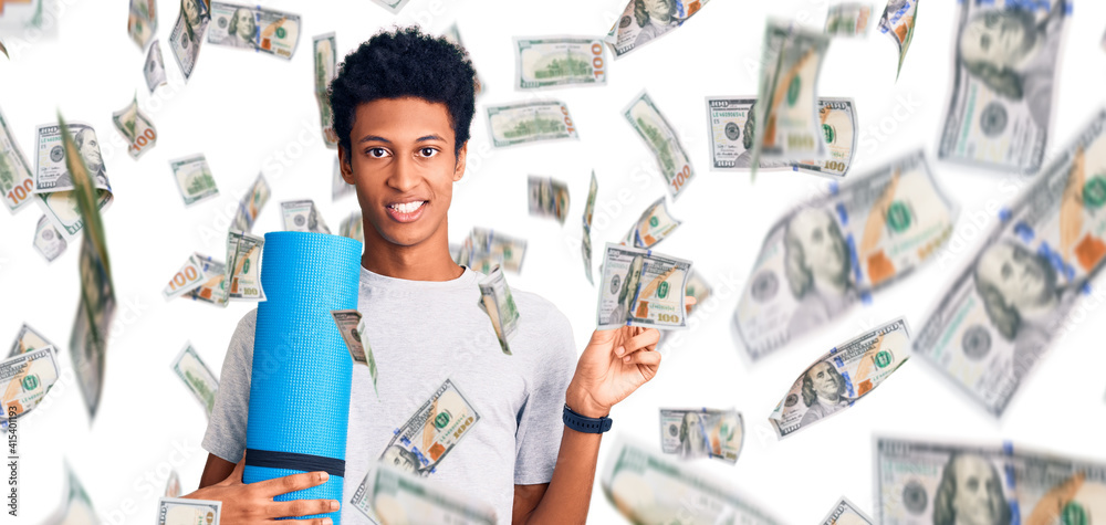 Young african american man holding yoga mat smiling happy pointing with hand and finger to the side Young african american man holding yoga mat smiling happy pointing with hand and finger to the side