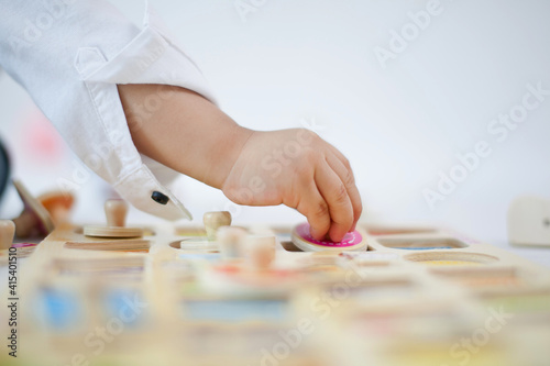 Close up hand of a toddler putting a puzzle, learning and development concept.