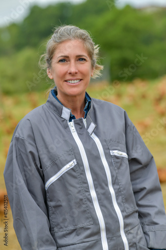Portrait of a smiling female farmer standing in the middle of her chicken farm