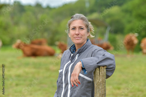 Portrait of a cattlewoman standing beside her cows