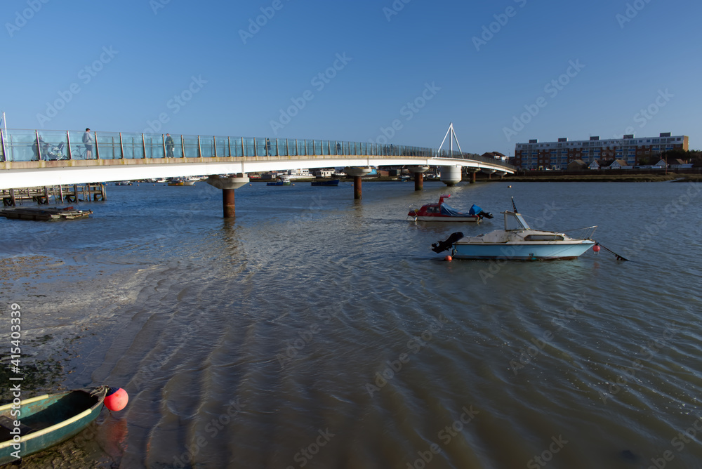 Obraz premium Two boats at anchor next to the Shoreham Adur Ferry Bridge which crosses the River Adur and link the main town to Shoreham by Sea.