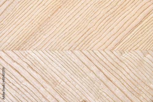 Wooden panel of ash veneer with stylish herringbone texture as background extreme close view from above