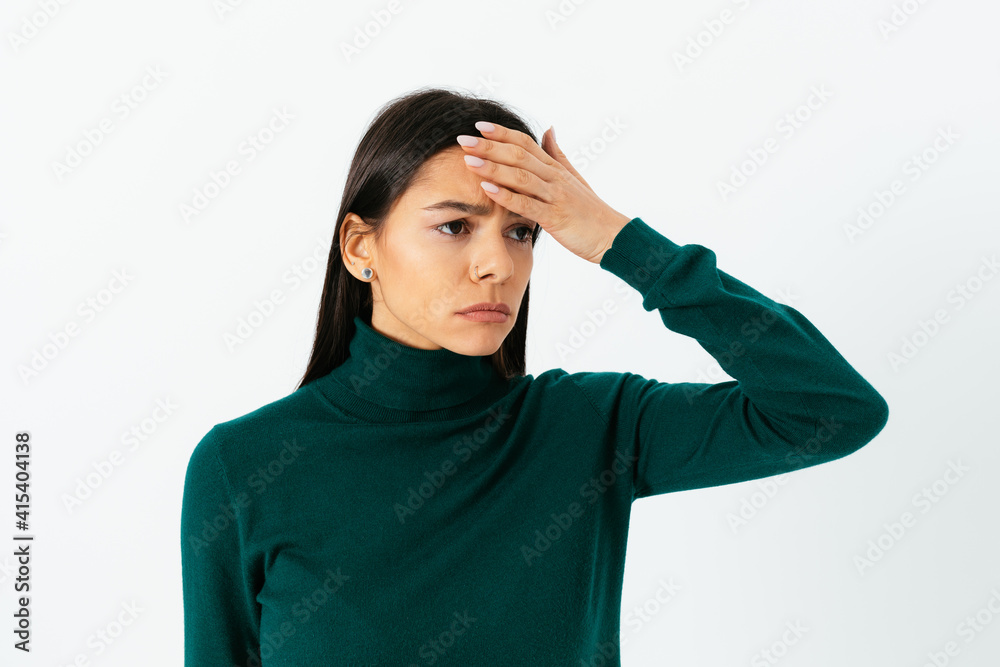 Sad young woman touching her forehead while suffering headache Sad young woman touching her forehead while suffering headache