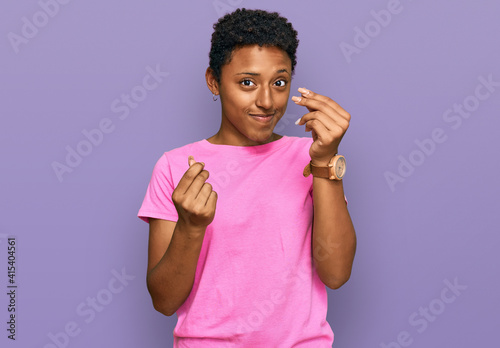 Young african american woman wearing casual clothes doing money gesture with hands, asking for salary payment, millionaire business