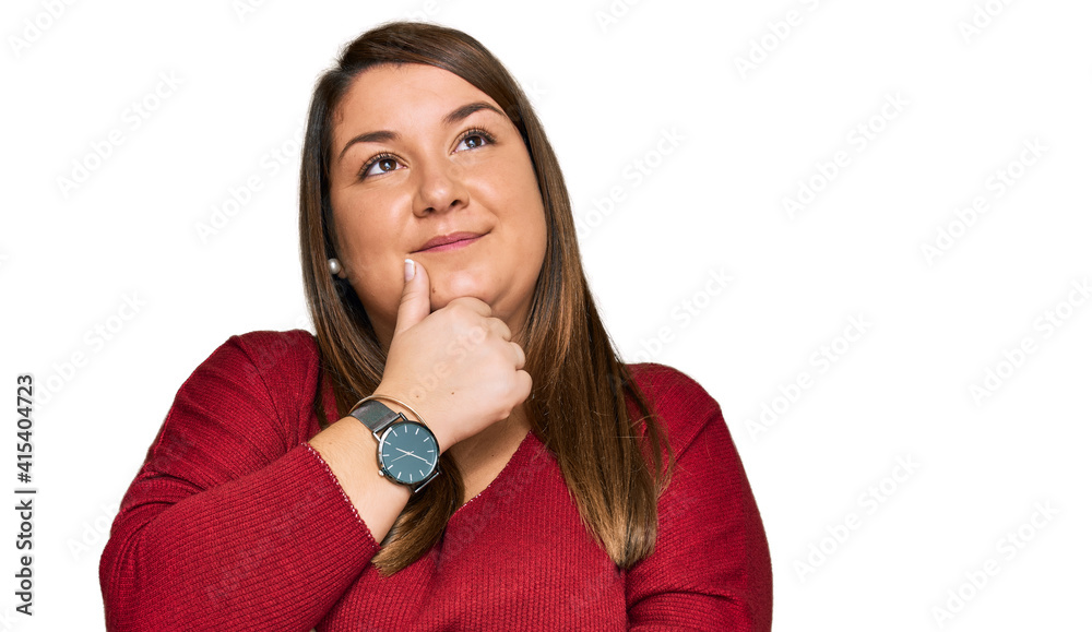 Beautiful brunette plus size woman wearing casual clothes with hand on chin thinking about question, pensive expression. smiling with thoughtful face. doubt concept. Beautiful brunette plus size woman wearing casual clothes with hand on chin thinking about question, pensive expression. smiling with thoughtful face. doubt concept.