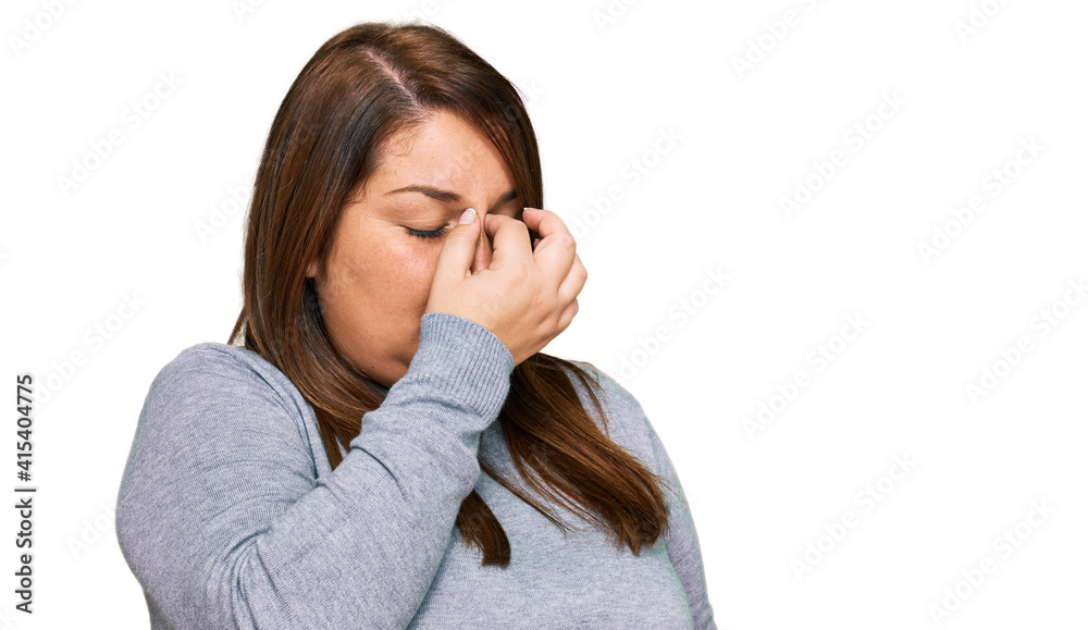 Beautiful brunette plus size woman wearing casual clothes tired rubbing nose and eyes feeling fatigue and headache. stress and frustration concept. Beautiful brunette plus size woman wearing casual clothes tired rubbing nose and eyes feeling fatigue and headache. stress and frustration concept.