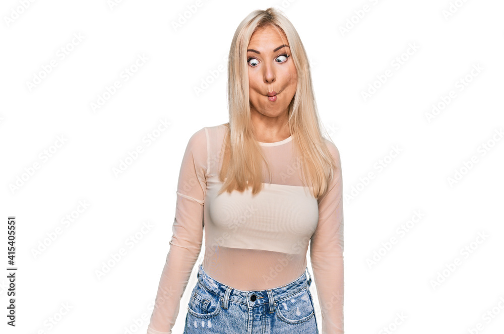 Young blonde woman wearing casual clothes making fish face with lips, crazy and comical gesture. funny expression. Young blonde woman wearing casual clothes making fish face with lips, crazy and comical gesture. funny expression.