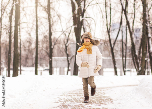 Boy runs on a path in the park in winter