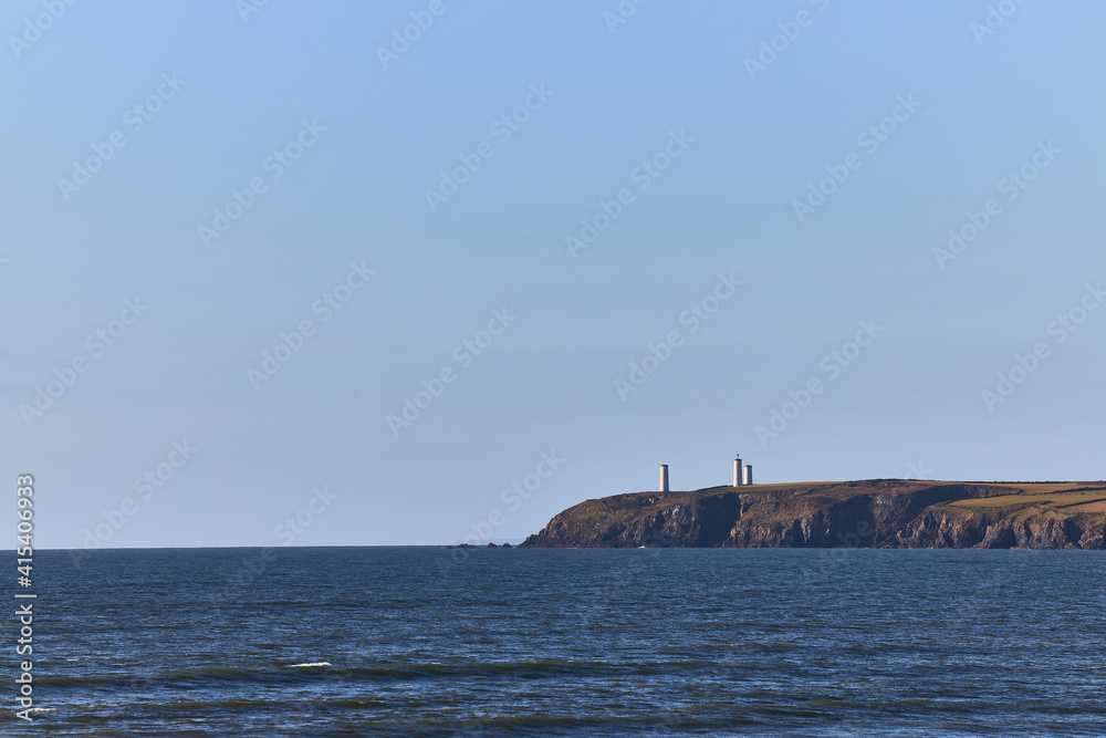 monument on cliff, distant view with ocean and clear sky with copy space. Metal man in Tramore. Waterford. Ireland.