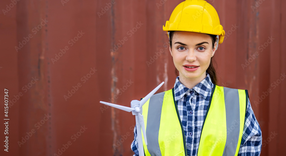 Creative female engineer worker holding a model of wind turbine, Portrait of beautiful woman with windmill miniature in hands face camera smiling Creative female engineer worker holding a model of wind turbine, Portrait of beautiful woman with windmill miniature in hands face camera smiling