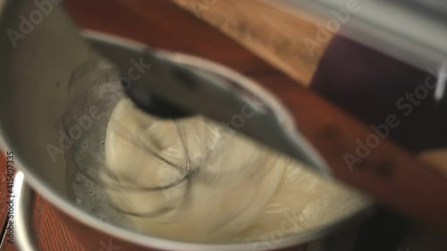 The electric mixer closeup quickly whips the egg white to a thick homogeneous mass, which is then used in cooking for dessert