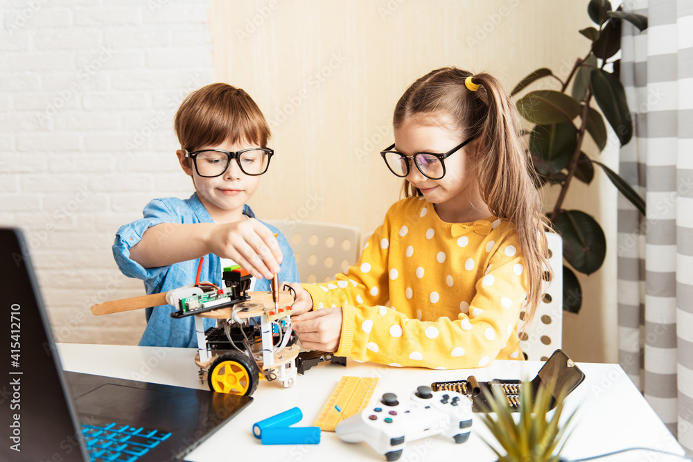 Happy kids programming and building science robotics project on his ...