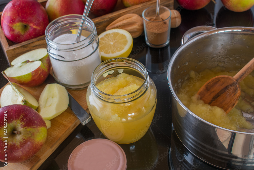 freshly cooked apple sauce pouring into a jar
