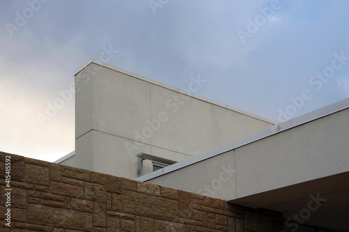 Low angle view of the upper part of a section of a modern building under a vivid autumn sky