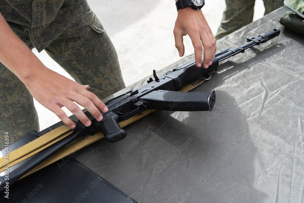 Military exercises using firearms. The soldier takes a machine gun for training shots. Unrecognizable person. Close-up Military exercises using firearms. The soldier takes a machine gun for training shots. Unrecognizable person. Close-up