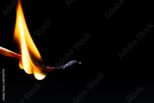 Attention, dangerously ignite a match in the woods, dry grass, a large fire flame on a black background