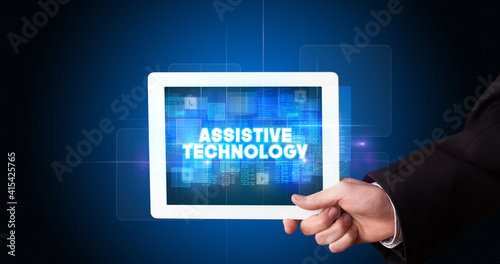 Wallpaper Mural Young business person working on tablet and shows the inscription: ASSISTIVE TECHNOLOGY Torontodigital.ca
