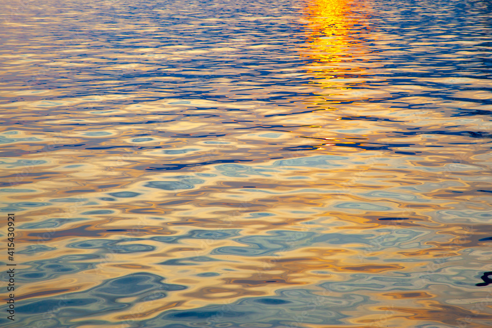 Colorful water surface with ripples at sunset Colorful water surface with ripples at sunset