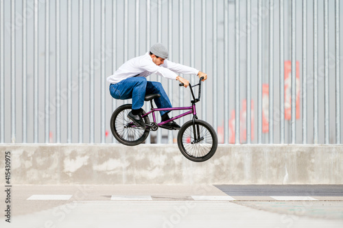 Young man performing tricks with a flatland bmx bike